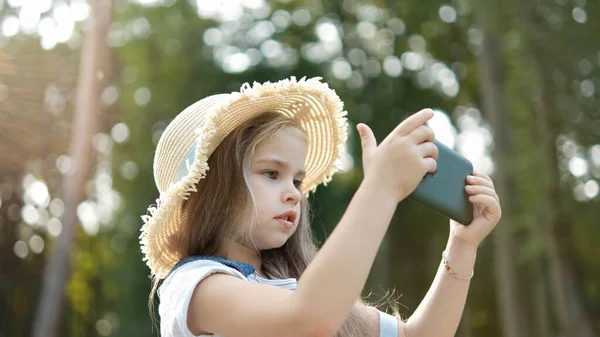 Glad Leende Barn Flicka Tittar Mobiltelefon Utomhus Sommaren — Stockfoto