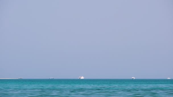 Seelandschaft mit welliger Oberfläche aus blauem Meerwasser mit weit entfernten Schiffen, die auf ruhigen Wellen schwimmen — Stockvideo