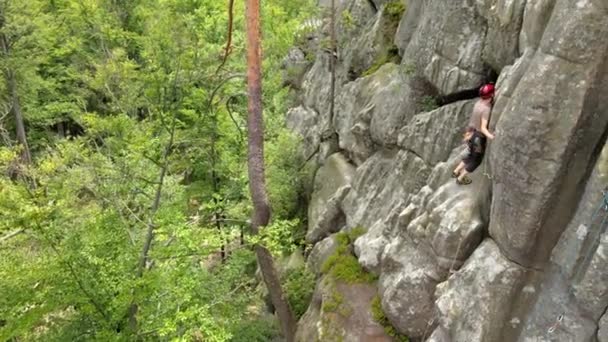 Junger Mann klettert steile Felswand hinauf. Männlicher Bergsteiger bewältigt anspruchsvolle Route Engagement im Extremsportkonzept — Stockvideo