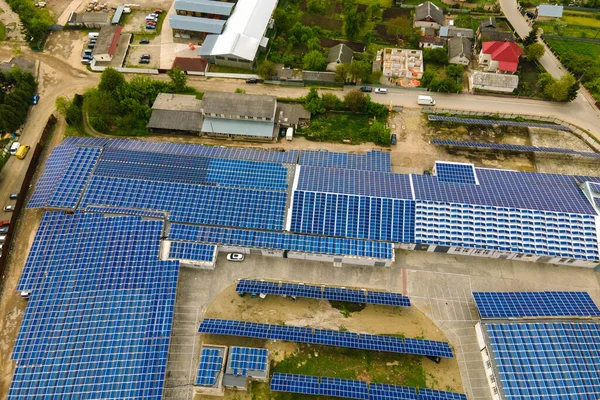 Letecký pohled na modré fotovoltaické solární panely namontované na střeše průmyslové budovy pro výrobu čisté ekologické elektřiny. Výroba koncepce obnovitelných zdrojů energie — Stock fotografie