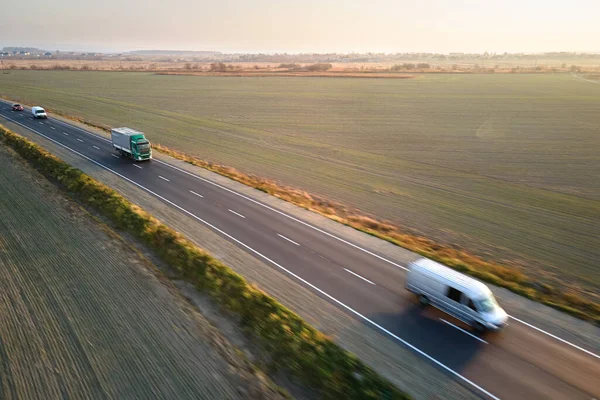Воздушный обзор грузовых автомобилей, движущихся по автодорожным перевозкам грузов. Концепция транспортировки и логистики — стоковое фото
