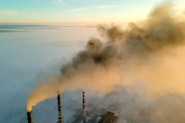 Vista aérea de las altas tuberías de las centrales eléctricas de carbón con humo negro subiendo por la atmósfera contaminante al atardecer —  Fotos de Stock