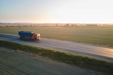 Akşamları kargo karavanıyla otobanda mal taşıyan yarı kamyonun hava görüntüsü. Teslimat ulaşım ve lojistik kavramı