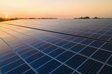 Mavi fotovoltaik güneş panelleri gün batımında temiz ekolojik elektrik üretmek için çatıya monte edildi. Yenilenebilir enerji konsepti üretimi