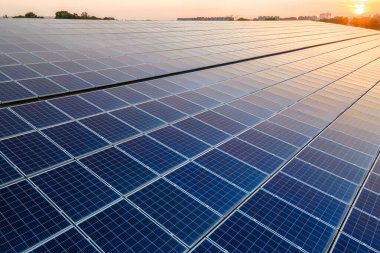 Mavi fotovoltaik güneş panelleri gün batımında temiz ekolojik elektrik üretmek için çatıya monte edildi. Yenilenebilir enerji konsepti üretimi