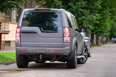 Şehrin caddesine park etmiş bir arabanın yakınına.
