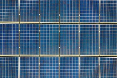 Mavi fotovoltaik güneş panellerinin yüzeyi, temiz ekolojik elektrik üretmek için çatıya monte edildi. Yenilenebilir enerji konsepti üretimi