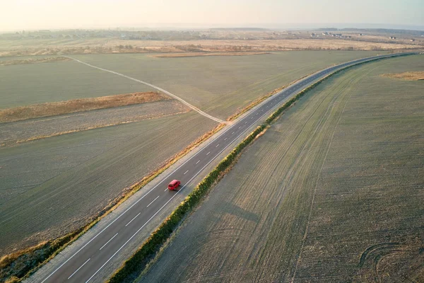 Vista aérea de la carretera interurbana con coche de conducción rápida borrosa al atardecer. Vista superior desde el dron del tráfico por carretera en la noche — Foto de Stock
