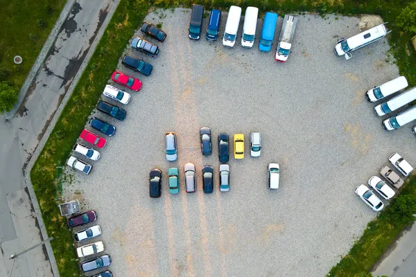 Вид с воздуха на множество красочных автомобилей, припаркованных на парковке вечером — стоковое фото
