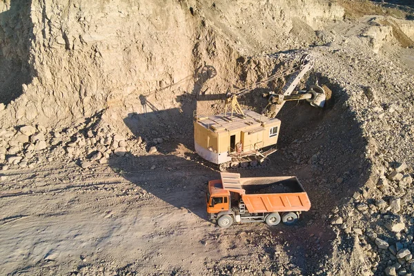 Vista aérea de mina a cielo abierto de materiales de arenisca para la industria de la construcción con camión volquete de carga de excavadoras con piedras. Equipo pesado en minería y producción de minerales útiles concepto — Foto de Stock
