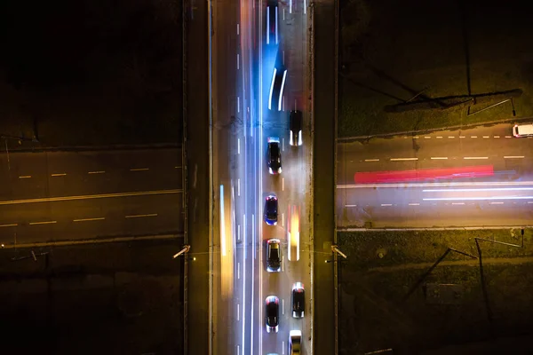 Luftaufnahme einer Straßenkreuzung mit starkem Verkehr in der Nacht. Blick von oben auf den städtischen Verkehr. Rush Hour mit Bewegungsunschärfe von Autofahrerampeln — Stockfoto