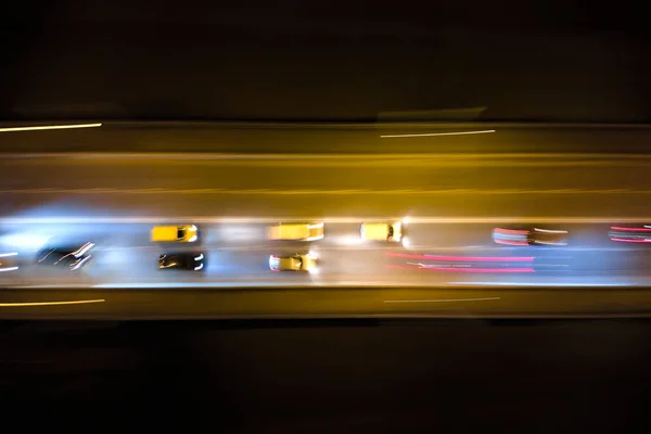 Вид с воздуха на дорогу с быстро движущимся интенсивным движением ночью. Вид сверху на городской транспорт. Час стирки при движении размывает дорожные огни — стоковое фото
