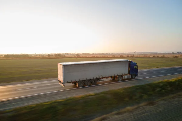Luchtfoto van semi-truck met lading trailer rijden op de snelweg goederenvervoer in de avond. Levering transport en logistiek concept — Stockfoto
