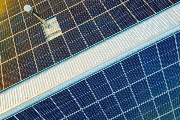 Luchtfoto van het oppervlak van blauwe fotovoltaïsche zonnepanelen gemonteerd op het dak van een gebouw voor de productie van schone ecologische elektriciteit. Productie van hernieuwbare energie — Stockfoto