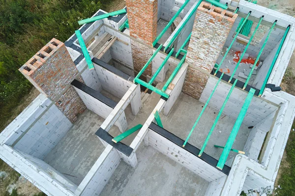 Vista aérea del marco inacabado de la casa privada con paredes de hormigón ligero aireado y vigas de madera en construcción —  Fotos de Stock