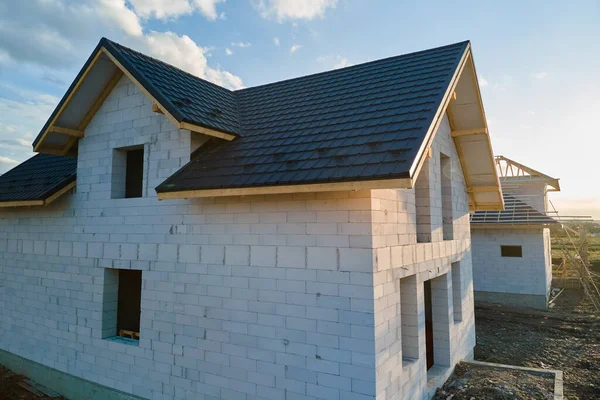 Luftaufnahme eines unfertigen Hauses mit Porenbeton-Leichtbetonwänden und Holzdachrahmen mit Metallziegeln im Bau — Stockfoto
