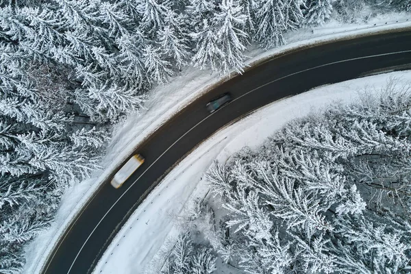 Aerial view of winter landscape with snow covered mountain woods and winding forest slippery road — Stock Photo, Image