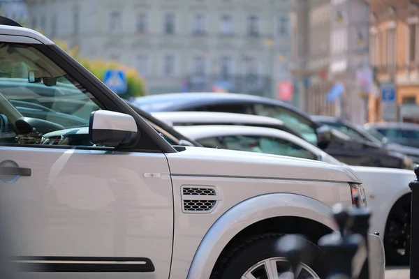 Городское движение с машинами, припаркованными в очереди на улице — стоковое фото