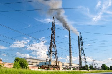 Kömür santraline karşı yüksek voltajlı elektrik direkleri siyah dumanlı yüksek borular atmosferi kirletiyor. Fosil yakıt kavramına sahip elektrik enerjisi üretimi