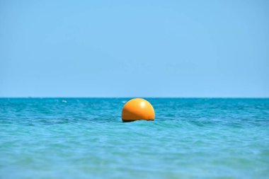 Deniz yüzeyinde yüzen turuncu şamandıra. İnsan hayatı güvenliği kavramı