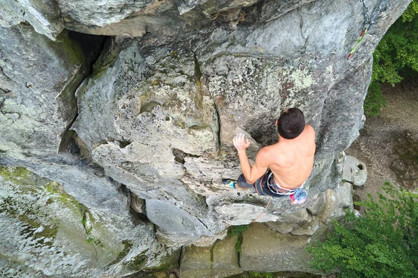 Déterminé grimpeur escalade mur escarpé de montagne rocheuse. Sportif surmonter la route difficile. S'engager dans des sports extrêmes et le concept de passe-temps d'escalade — Photo
