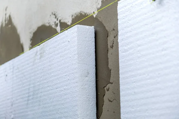 Installation of styrofoam insulation sheets on house facade wall for thermal protection — Stock Photo, Image