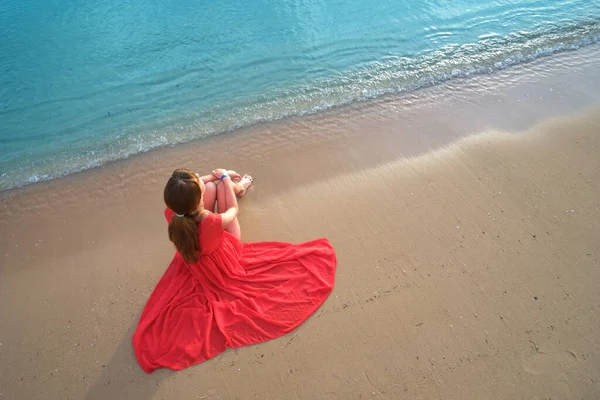 Solitario giovane donna seduta sulla spiaggia di sabbia oceanica dal mare godendo calda serata tropicale — Foto Stock