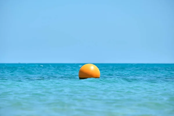 Deniz yüzeyinde yüzen turuncu şamandıra. İnsan hayatı güvenliği kavramı — Stok fotoğraf