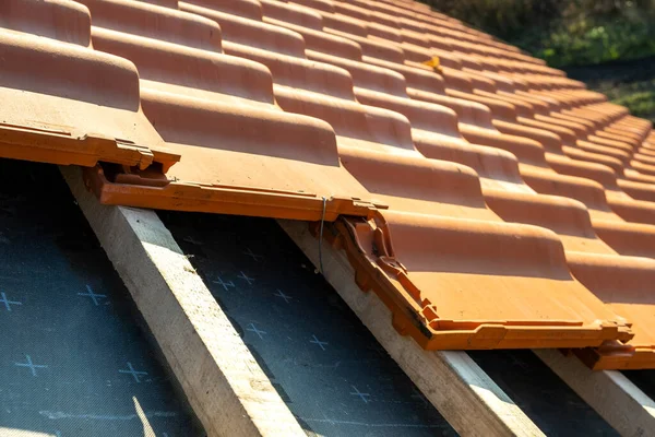 建築中の住宅用屋根を覆う板に取り付けられた黄色のセラミック屋根瓦の重なり合う列 — ストック写真