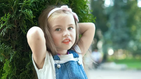 Portret szczęśliwej ślicznej dziewczynki stojącej w letnim parku patrzącej w kamerę — Zdjęcie stockowe