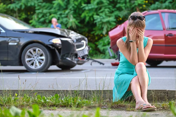 Conductora triste sentada en el lado de la calle sorprendida después de un accidente de coche. Concepto de seguridad vial y seguro de vehículos — Foto de Stock