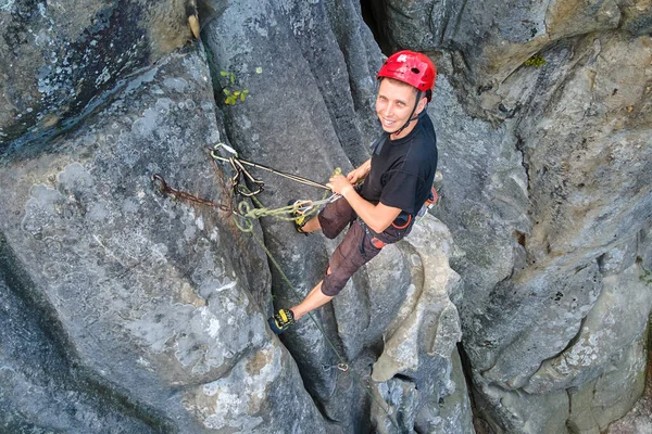 Sterke mannelijke klimmer klimmende steile muur van rotsachtige berg. Sportman overwint moeilijke route. Betrokken bij extreme sport hobby concept — Stockfoto