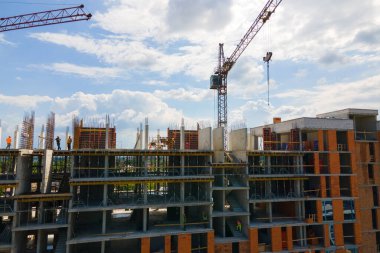İnşaat halindeki yüksek beton bina kulesindeki vinç. Gayrimenkul geliştirme kavramı