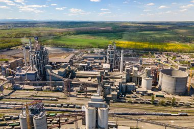 Yüksek beton yapısı olan çimento fabrikasının havadan görünüşü ve endüstriyel üretim alanında kule vinci. Üretim ve küresel sanayi kavramı