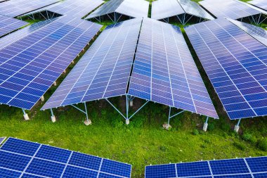 Temiz ekolojik elektrik enerjisi üretmek için sıra sıra güneş fotovoltaik panelleri olan sürdürülebilir büyük elektrik santralinin havadan görünüşü. Sıfır emisyon kavramı ile yenilenebilir elektrik