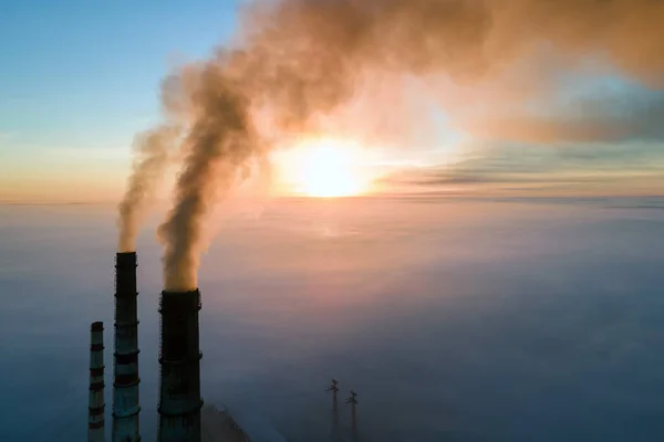 Uitzicht vanuit de lucht op hoge pijpen van kolencentrales met zwarte rook die bij zonsondergang de vervuilende atmosfeer opgaat — Stockfoto