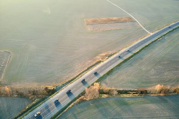 Vista aérea de la carretera interurbana con coches de conducción rápida al atardecer. Vista superior desde el dron del tráfico por carretera en la noche — Foto de Stock