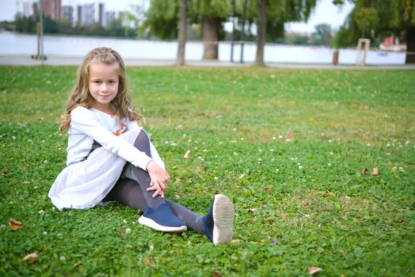 Retrato de niña bonita al aire libre acostada en el césped de hierba —  Fotos de Stock
