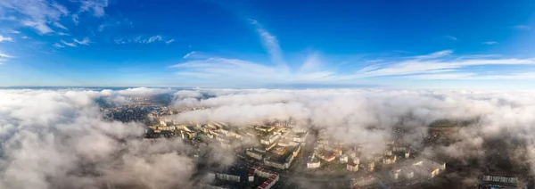 高層ビルが立ち並ぶ近代都市の上からのふわふわした白い雲の空中写真 — ストック写真