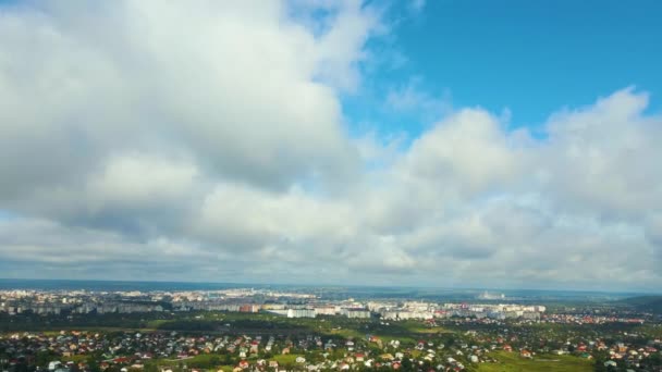 Aerial view from high altitude of distant city covered with puffy cumulus clouds forming before rainstorm — Stock Video