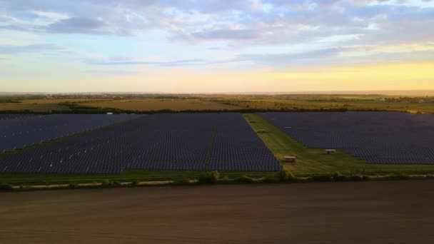 Letecký pohled na velkou udržitelnou elektrárnu s řadami solárních fotovoltaických panelů pro výrobu čisté ekologické elektrické energie při západu slunce. Obnovitelná elektřina s koncepcí nulových emisí — Stock video