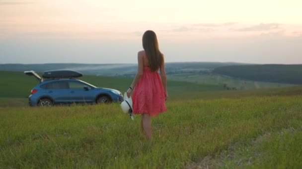 Jovem caminhando sozinha no campo verde durante a viagem de estrada no verão. Viajar de carro conceito — Vídeo de Stock
