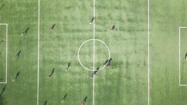 Yeşil spor stadyumunda futbol oynayan futbolcuların hava manzarası