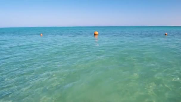 Orangefarbene Boje schwimmt auf Wellen an der Meeresoberfläche. Sicherheitskonzept für das menschliche Leben — Stockvideo