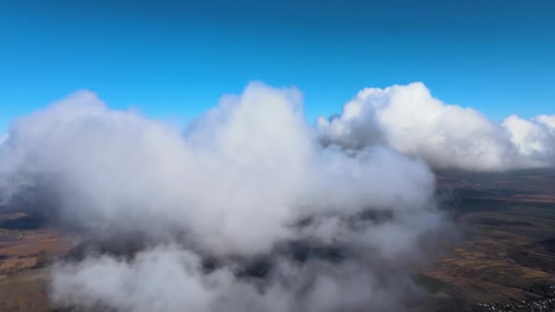 하늘 높이 떠 있는 비행기 창문에서 흰 솜털 뭉치 구름으로 덮여 있는 지구 의고 도에서 바라본 공중 광경 — 비디오