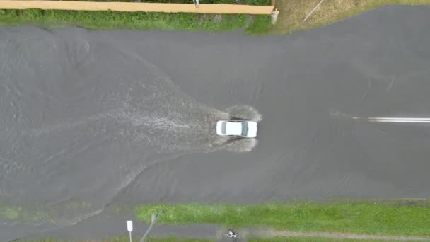 Вид с воздуха на городское движение с автомобилями, движущимися по затопленной улице после сильного дождя. Проблемы с системой дренажа — стоковое видео