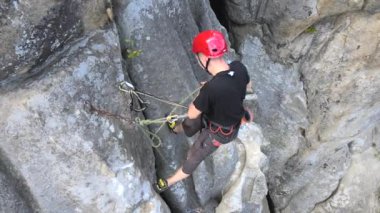 Kararlı dağcı kayalık dağın dik duvarına tırmanıyor. Sporcu zor yolu aştı. Ekstrem sporlar ve kaya tırmanışı hobileri.