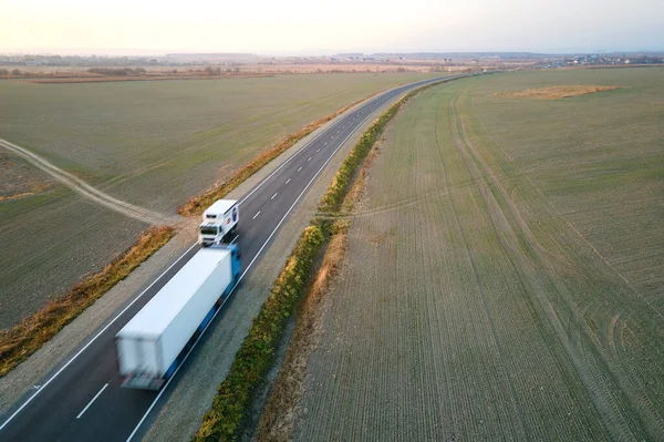 Воздушный обзор грузовых автомобилей, движущихся по автодорожным перевозкам грузов. Концепция транспортировки и логистики — стоковое фото