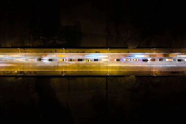 Luftaufnahme einer Straße mit starkem Verkehr in der Nacht. Blick von oben auf den städtischen Verkehr. Rush Hour mit Bewegungsunschärfe von Autofahrerampeln — Stockfoto