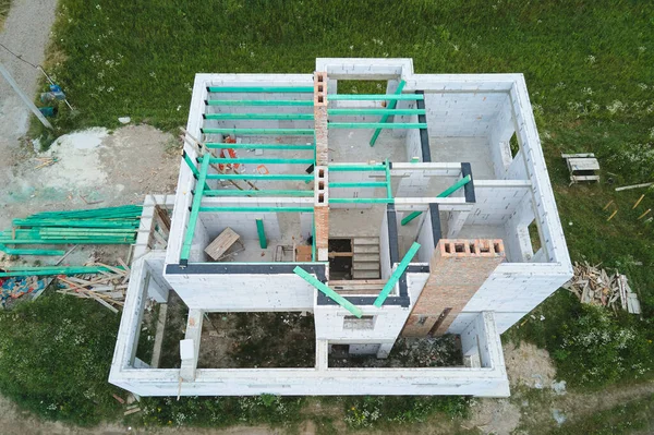 Vue aérienne du cadre inachevé de la maison privée avec murs en béton léger aéré et poutres de toit en bois en construction — Photo